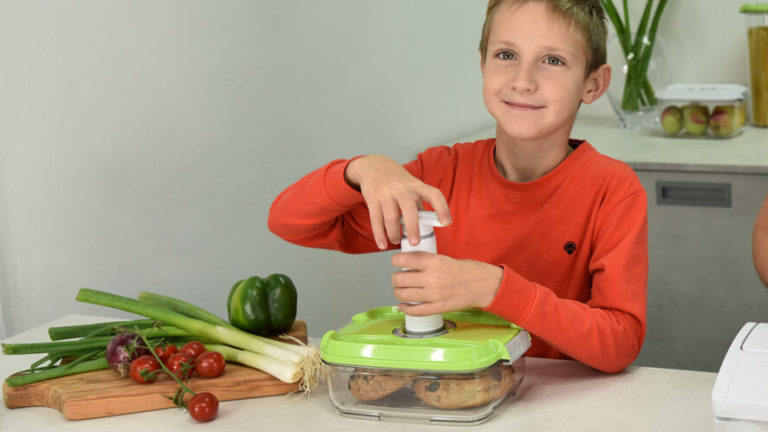 a boy vacuum packing food in a container